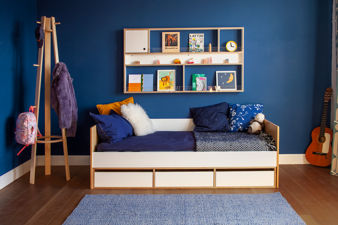Birch and white cabina twin daybed with simple solid wood frame and 3 drawers at base in blue walled room with floating shelf.